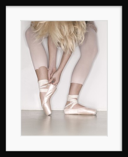 Ballerina adjusting toe shoe by Anonymous