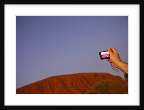 Tourist photographing Ayers Rock in the Australian Outback by Anonymous