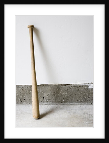Detail of wooden baseball bat against white and concrete wall. by Anonymous