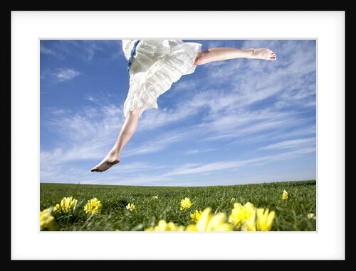 Young woman in park jumping on lawn by Anonymous