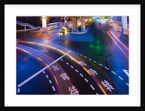 Traffice moving through intersection at night by Anonymous