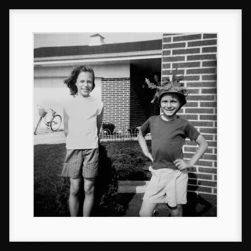 Brother and sister playing in front of their house, ca. 1965 by Anonymous