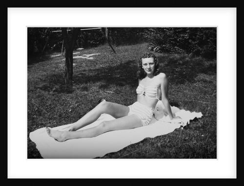 Sixteen year old girl sun tans on a blanket, ca. 1944 by Anonymous
