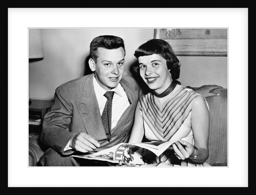 A couple pose on a couch while reading LIFE magazine, ca. 1955 by Anonymous