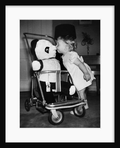 A two year old girl kisses a stuffed panda on the nose, ca. 1955 by Anonymous