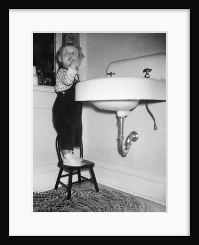 A young girl brushes her teeth at the sink, ca. 1955 by Anonymous