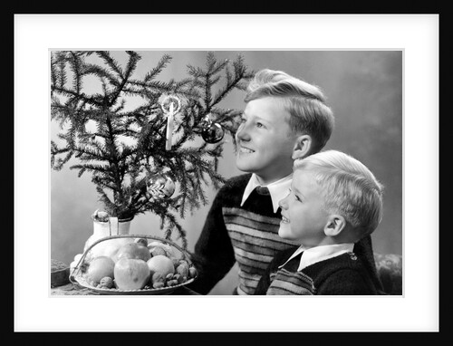 Two brothers look at a candle on a Christmas tree in Germany, ca. 1950 by Anonymous