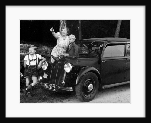Mother stands next to her two sons sitting on the hood of their Mercedes automobile, ca. 1948 by Anonymous