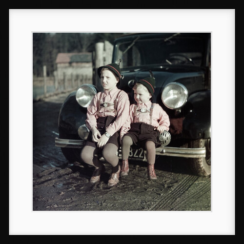 Two brothers sit on the bumper of the family Mercedes Benz in Germany, ca. 1949 by Anonymous