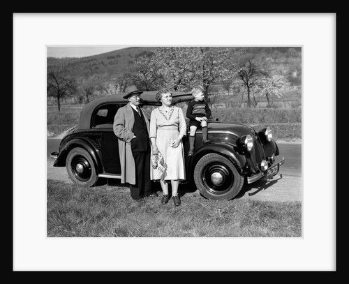 Father and mother stand with their son sitting on the hood of their Mercedes automobile, ca. 1950 by Anonymous