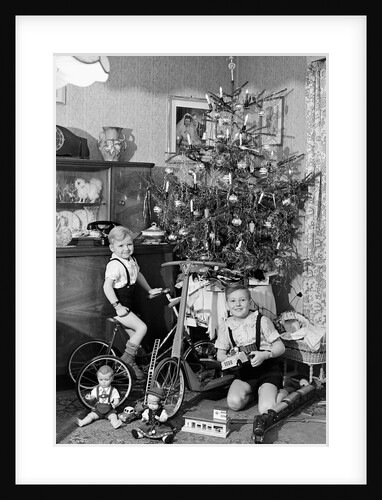 Two brothers are shown with their toys under the Christmas tree in Germany, ca. 1949 by Anonymous