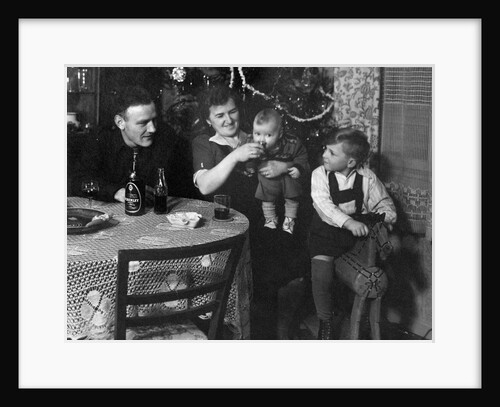 One year old baby boy gets a drink of Coca Cola in front of the Christmas tree, ca. 1946 by Anonymous
