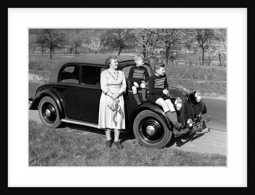 Mother stands next to her two sons sitting on the hood of their Mercedes automobile, ca. 1950 by Anonymous