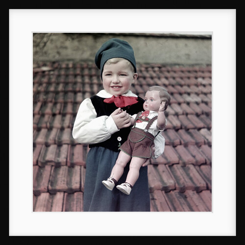 Four year old German boy stands with his lederhosen dressed doll, ca. 1949 by Anonymous