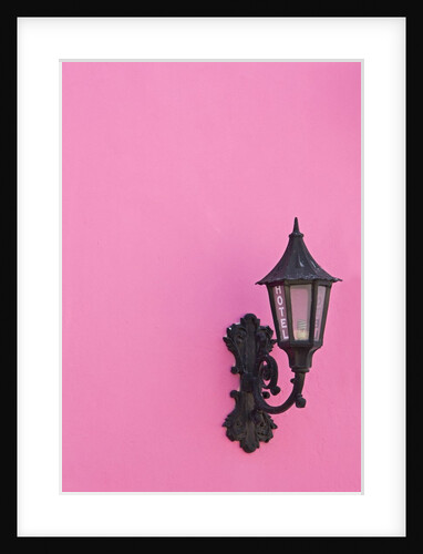 Street lamp on pink wall of Colonial style building by Anonymous