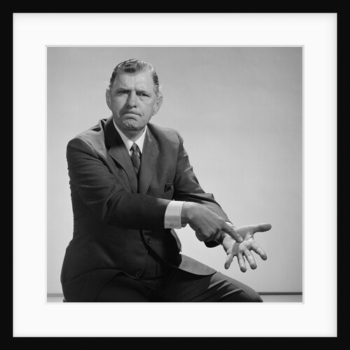 Angry man pointing to palm of his hand by Anonymous