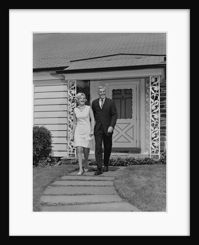 Mature couple walking on sidewalk front of house by Anonymous