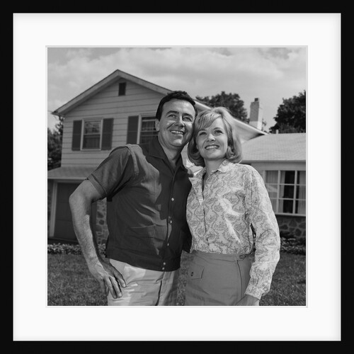 Happy couple portrait man woman smiling in front of home by Anonymous