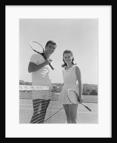 Portrait tennis couple man woman holding racquets standing by net by Anonymous