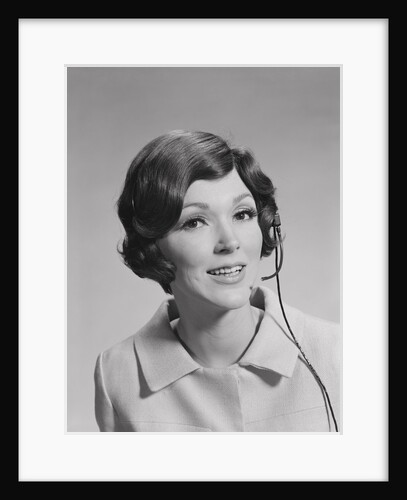 Smiling brunette woman wearing telephone head set by Anonymous