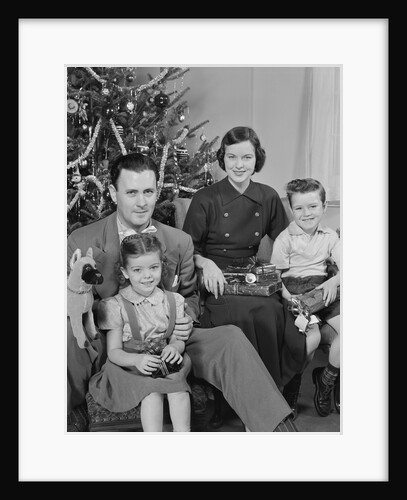 Family portrait by christmas tree by Anonymous