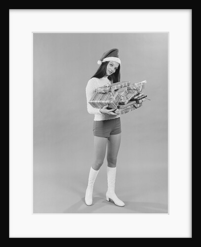 Young woman wearing santa claus hat hot pants go-go boots holding wrapped christmas presents by Anonymous