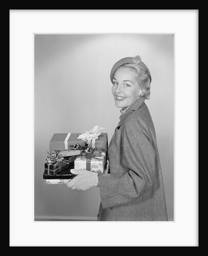 Smiling woman holding wrapped christmas presents by Anonymous