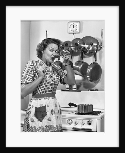 Housewife tasting with spoon by stove funny facial expression by Anonymous
