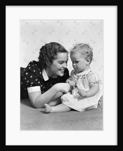 Woman mother smiling sitting playing with baby daughter by Anonymous