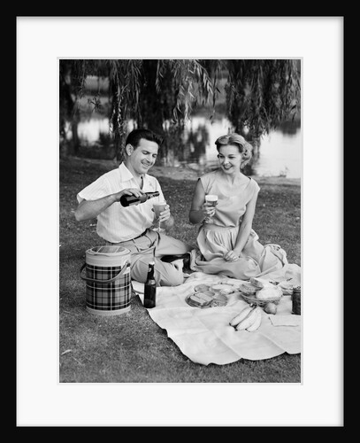 Man woman couple having a summer picnic outdoors drinking beer by Anonymous