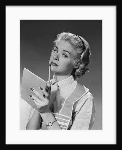 Blond woman wearing apron writing pad in hand pencil to chin thinking by Anonymous