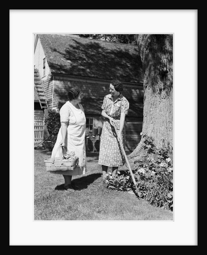 Two women talking in yard one holding garden hoe the other holds basket with flowers by Anonymous