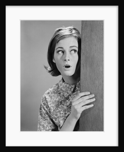 Woman peeking around door corner with fearful expression by Anonymous