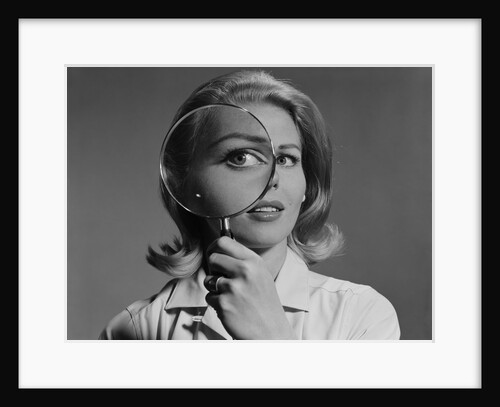 Blond woman magnifying glass held up to and enlarging one eye by Anonymous