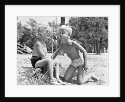 Blonde boy girl wearing bathing suits blowing on a pinwheel toy summer by Anonymous