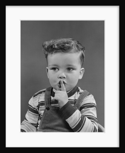 Little boy making shush shushing quiet silence sign with finger to mouth lips by Anonymous