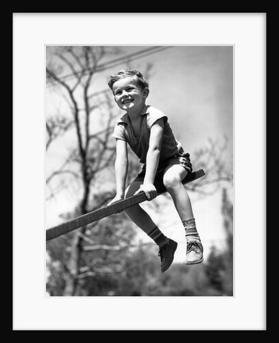 Boy on seesaw smiling by Anonymous