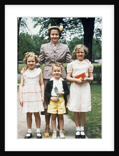 Mother and three children all dressed up posing for photo outdoors by Anonymous