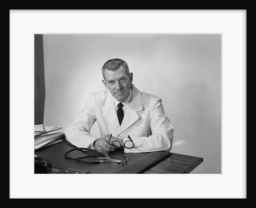 Portrait male doctor sitting at desk serious expression by Anonymous