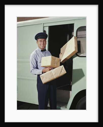 Delivery truck driver holding packages by Anonymous