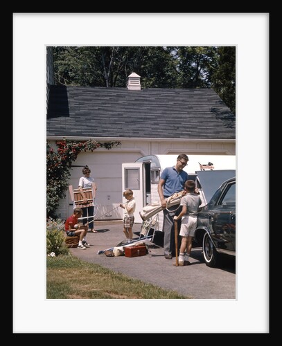 Family father mother 3 sons loading car and trailer for camping vacation by Anonymous