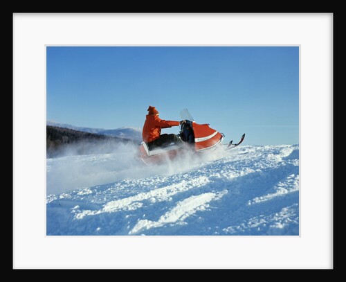 Man wearing red jacket and hat driving snowmobile by Anonymous