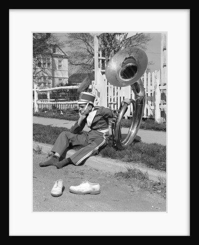 Teen boy band uniform & tuba sitting on curb with shoes off by Anonymous