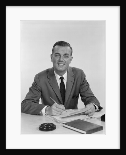 Smiling happy businessman pen in hand signing papers at desk by Anonymous