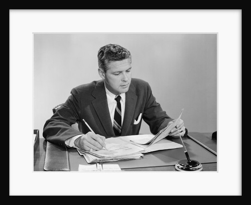 Businessman at desk looking over files papers making notes with pencil by Anonymous