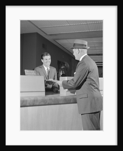 Businessman making a deposit into savings account with bank teller by Anonymous