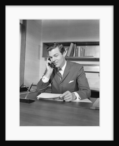 Businessman executive at desk talking on telephone by Anonymous