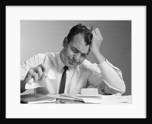Frustrated businessman hand to forehead crumpling paper in hand by Anonymous
