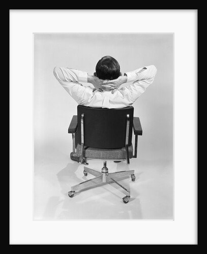 Man from behind sitting in office executive chair hands clasped behind neck by Anonymous