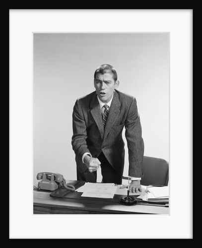 Angry upset businessman pounding fist into desk by Anonymous